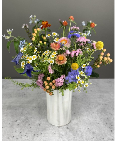 Seasonal wildflower arrangement with colorful, natural blooms in a rustic, meadow-inspired style.