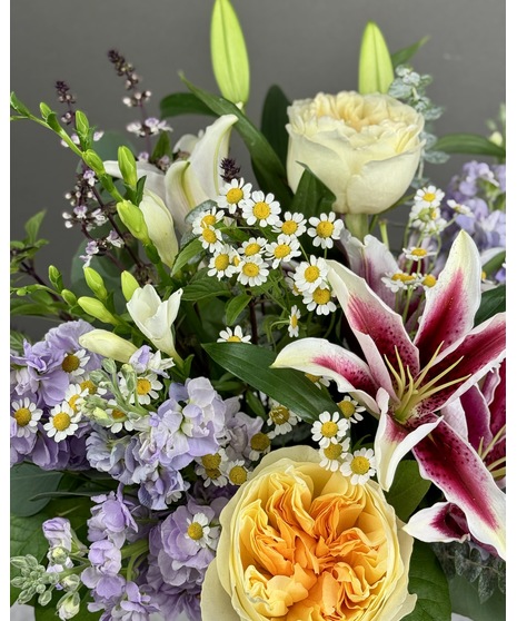Floral arrangement made with seasonal, fragrant flowers in varying colors and sizes.