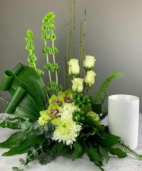 Urn or photo floral accent with mixed greenery and soft white blooms. Designed to fit your keepsake’s dimensions.