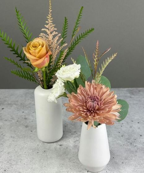Boho arrangement with protea, roses, lisianthus, and textured blooms in blush, gold, ivory, and mauve tones.