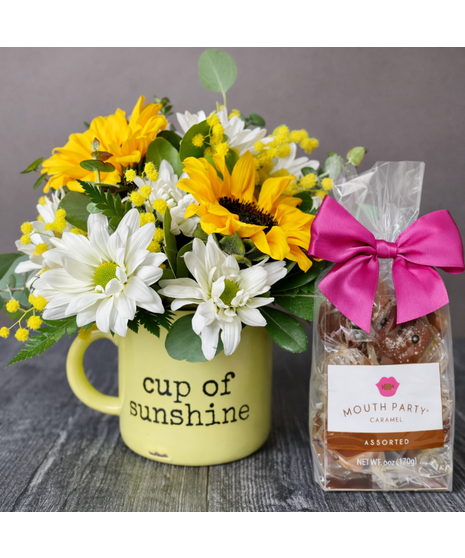 Yellow sunflowers and white daisies with greenery in a custom WildFlower mug. Optional tea and caramel add-ons.