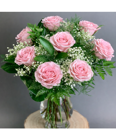 Long-stem assorted roses with seasonal accent flowers and greenery in a clear glass vase.