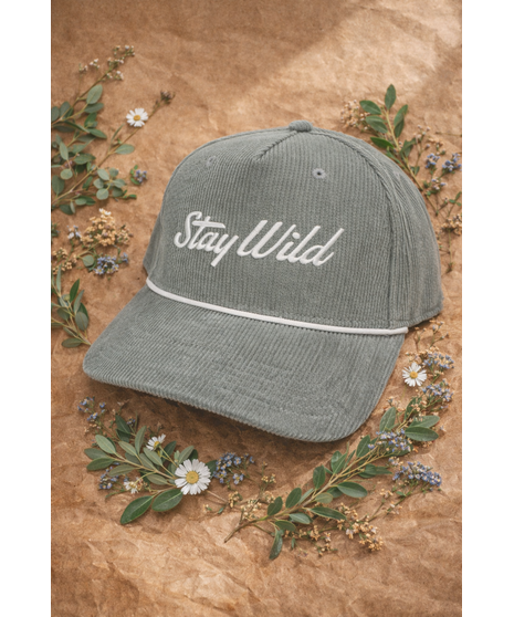 A corduroy hat with an embroidered ‘Stay Wild’ logo, white rope detail, and adjustable strap. Available in four colors.