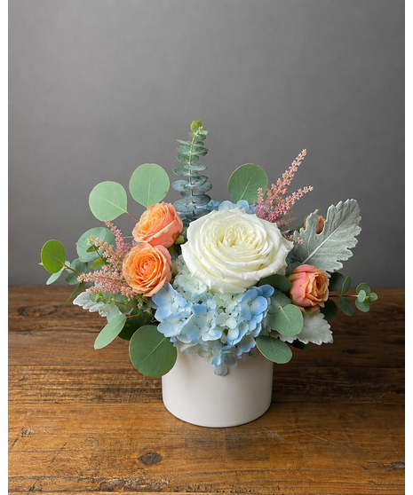 Wedding centerpiece with peach roses, delphinium, Queen Anne’s lace, and eucalyptus. Available in petite or full size.