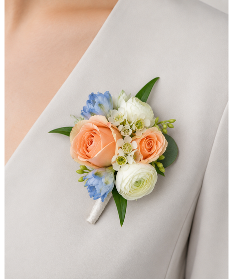 Wedding corsage with peach roses, delphinium, and greenery. Available in wrist or magnet style.