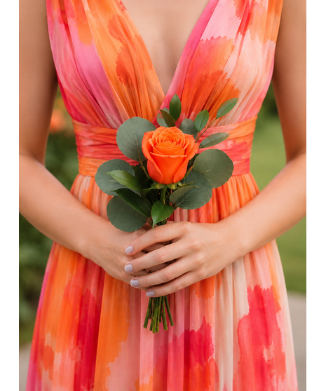 Colorful bridal party flowers in vibrant pink, peach, orange, and yellow tones with lush greenery and whimsical texture.