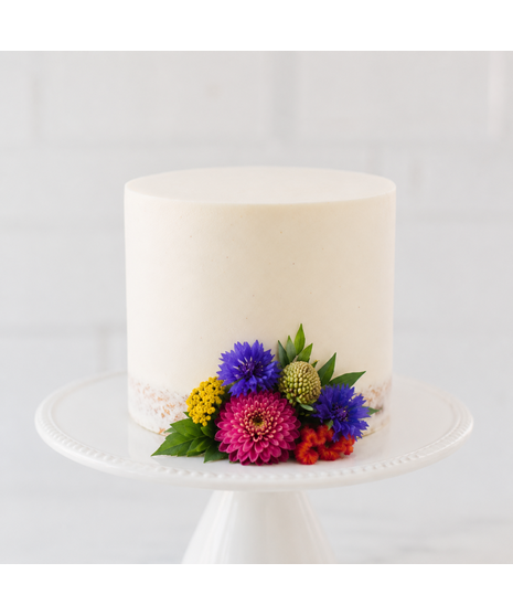 Bright seasonal flowers in bold hues designed to decorate a wedding cake.