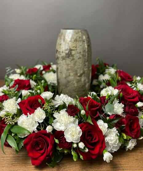 Red and white flowers arranged around a keepsake such as an urn or photo. Please provide dimensions.