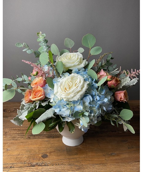 Wedding centerpiece with peach roses, delphinium, Queen Anne’s lace, and eucalyptus. Available in petite or full size.