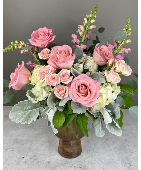 A floral arrangement featuring pink and white blooms, including blush roses, white lilies, and pink hydrangeas. Perfect for elegant and joyful celebrations.