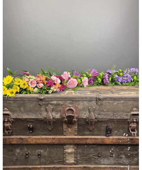 Bright and colorful floral designs for casket inserts, including pillows, garlands, and adornments.