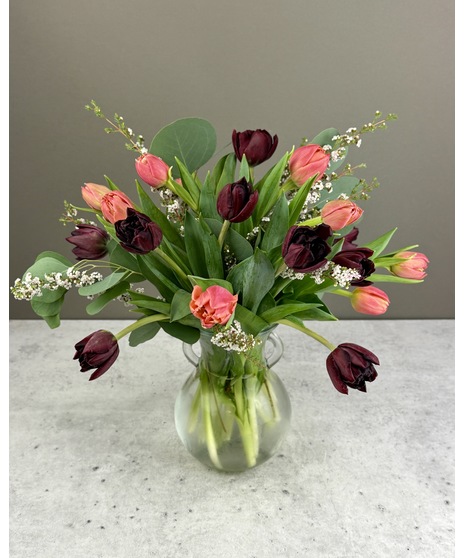 Chesapeake grown tulips arranged with greenery and seasonal accents in a glass vase.