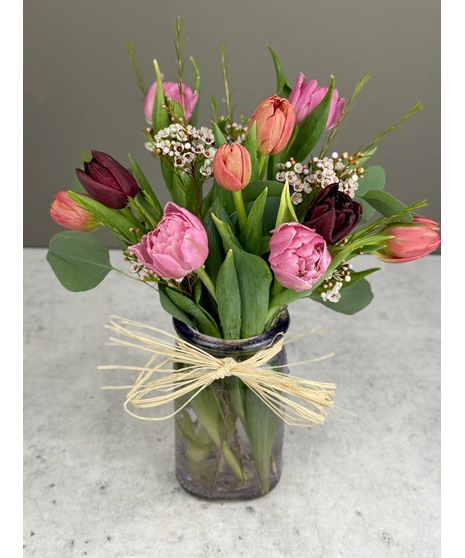 Chesapeake grown tulips arranged with greenery and seasonal accents in a glass vase.