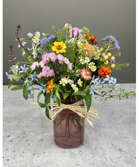 Colorful seasonal flower arrangement in a vase, mason jar, or bloom bottle trio.