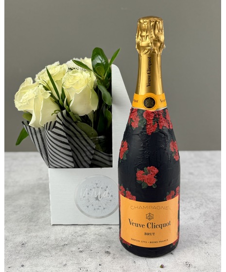 Colorful flower arrangement with a bottle of Prosecco or Champagne in a gift caddy.