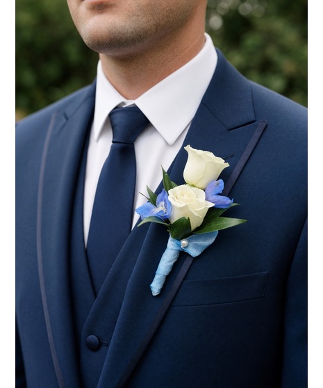 White and soft blue wedding boutonniere with greenery, available in groom, attendant, or floral pocket square style.