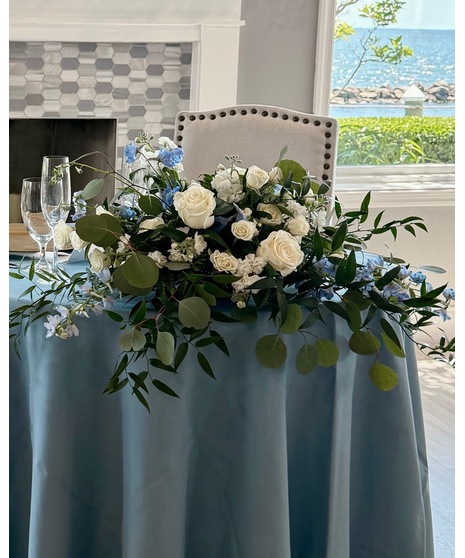 Wedding centerpiece with peach roses, delphinium, Queen Anne’s lace, and eucalyptus. Available in petite or full size.