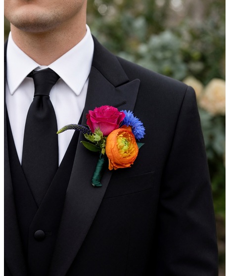 A vibrant wedding boutonniere and floral pocket square collection featuring bold, colorful blooms with playful texture and artistic garden-inspired styling.