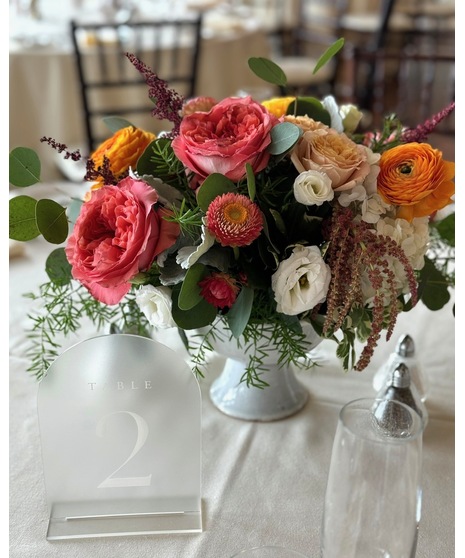 Bright citrus-inspired wedding centerpieces in orange, peach, yellow, and pink tones for dining, cocktail, and reception tables.