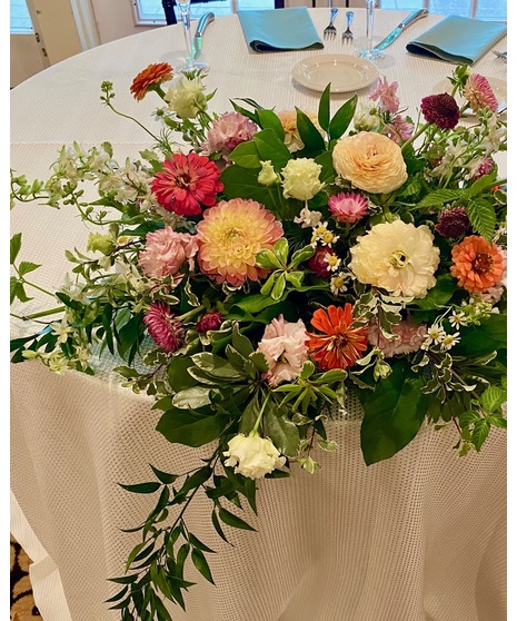 Bright citrus-inspired wedding centerpieces in orange, peach, yellow, and pink tones for dining, cocktail, and reception tables.