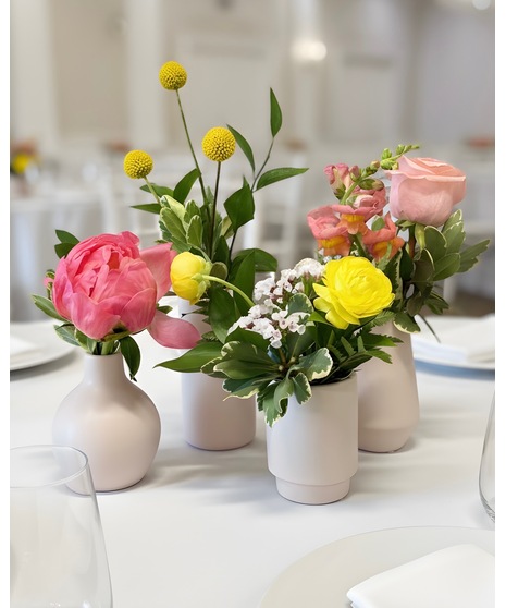 Bright citrus-inspired wedding centerpieces in orange, peach, yellow, and pink tones for dining, cocktail, and reception tables.