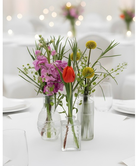 Bright citrus-inspired accent wedding flowers in orange, peach, yellow, and pink tones for cocktail tables, bars, and décor accents.
