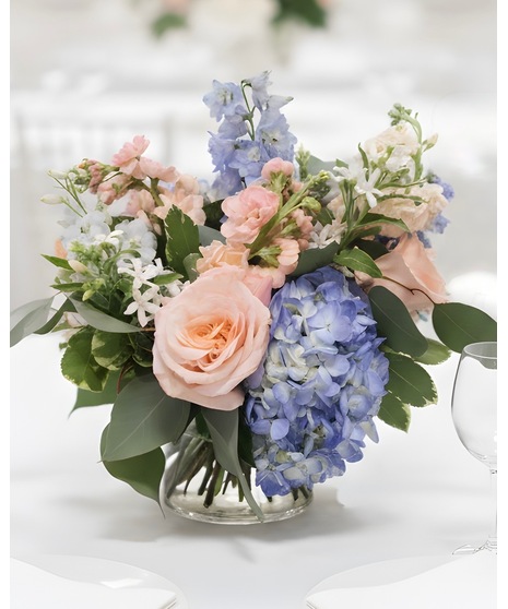 Wedding centerpiece with peach roses, delphinium, Queen Anne’s lace, and eucalyptus. Available in petite or full size.