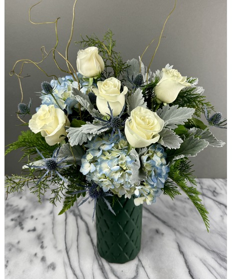 Winter blue and white arrangement with roses, hydrangea, and thistle in cool tones.