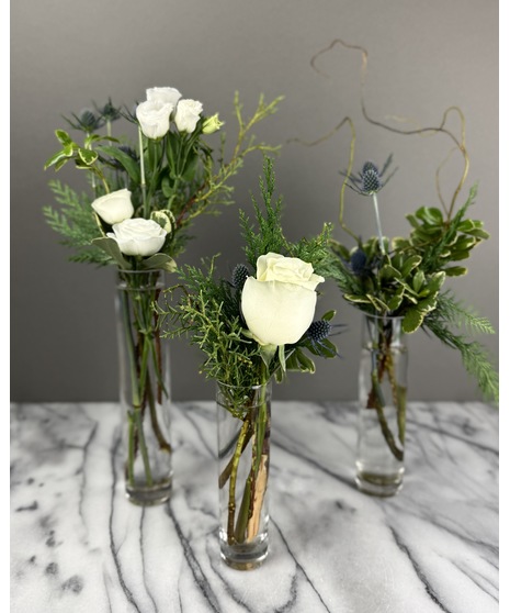 Winter blue and white arrangement with roses, hydrangea, and thistle in cool tones.