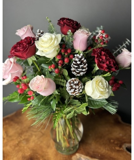 n arrangement of fresh roses in holiday colors with greenery, pinecones, and white berries. Available in sizes from 1 rose to 100.