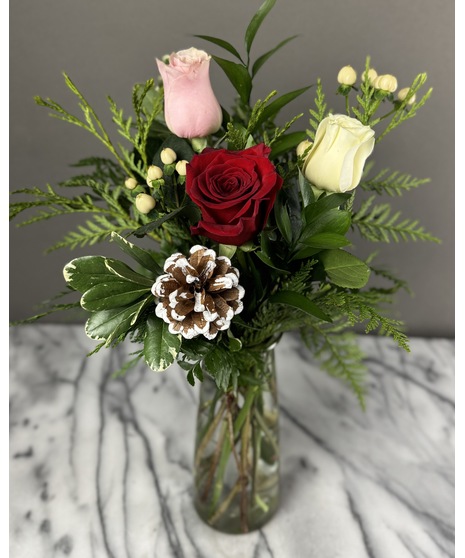 n arrangement of fresh roses in holiday colors with greenery, pinecones, and white berries. Available in sizes from 1 rose to 100.
