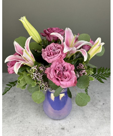 A floral arrangement featuring roses and lilies.