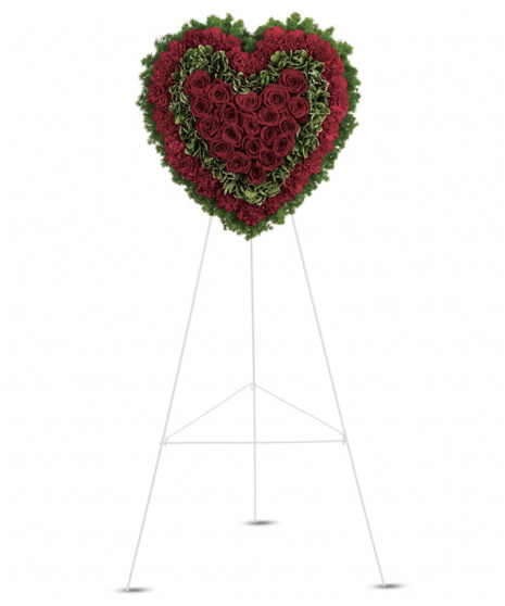 A heart-shaped sympathy wreath in shades of red and white with green accents, displayed on a standing easel with a broken heart effect.