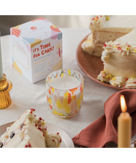 Colorful hand-blown glass candle with festive fragrance options, packaged in a gift box with space for a personal message.