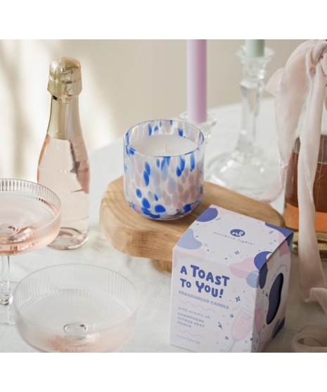 Colorful hand-blown glass candle with festive fragrance options, packaged in a gift box with space for a personal message.