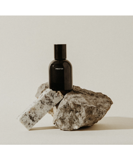 Black glass men’s cologne bottle with minimalist labeling, available in multiple scents.