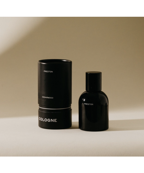 Black glass men’s cologne bottle with minimalist labeling, available in multiple scents.