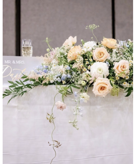 Wedding centerpiece with peach roses, delphinium, Queen Anne’s lace, and eucalyptus. Available in petite or full size.