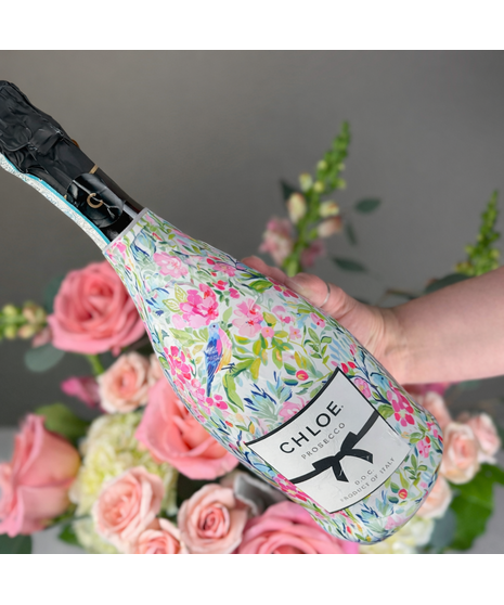 Deep jewel-toned flower arrangement paired with a premium bottle of champagne or wine