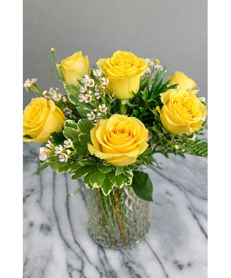 Long-stem assorted roses with seasonal accent flowers and greenery in a clear glass vase.