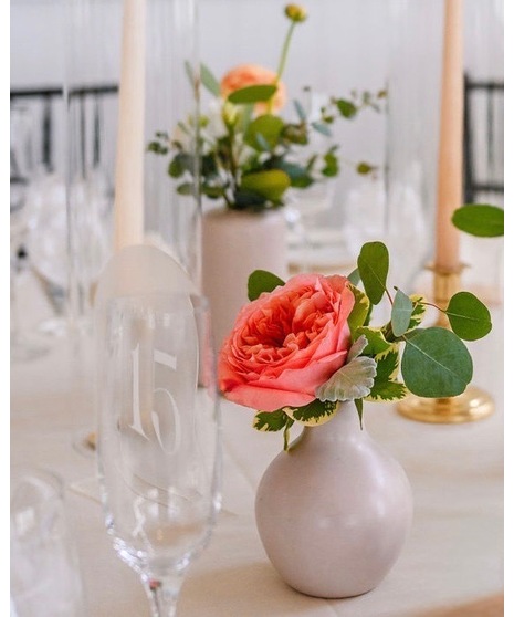 Bright citrus-inspired wedding centerpieces in orange, peach, yellow, and pink tones for dining, cocktail, and reception tables.