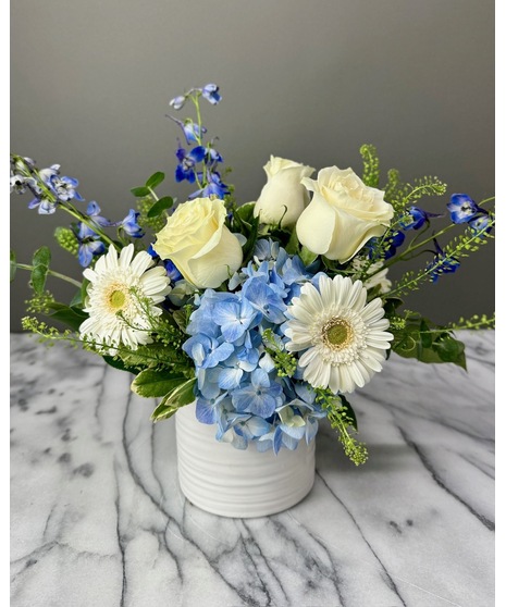 Wedding centerpiece with peach roses, delphinium, Queen Anne’s lace, and eucalyptus. Available in petite or full size.