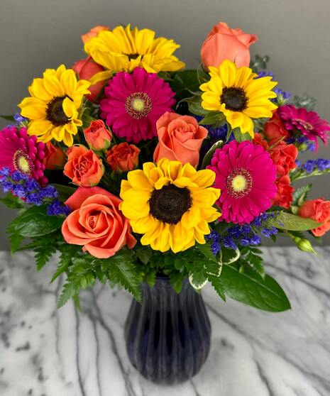 Bright, colorful arrangement of bold seasonal blooms in a vibrant designer’s mixed assortment.