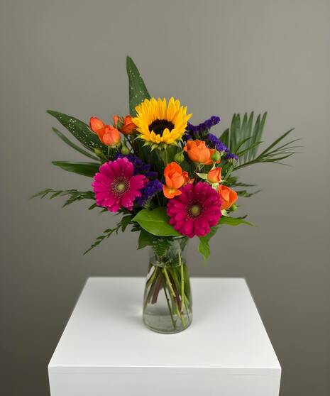 Bright, colorful arrangement of bold seasonal blooms in a vibrant designer’s mixed assortment.