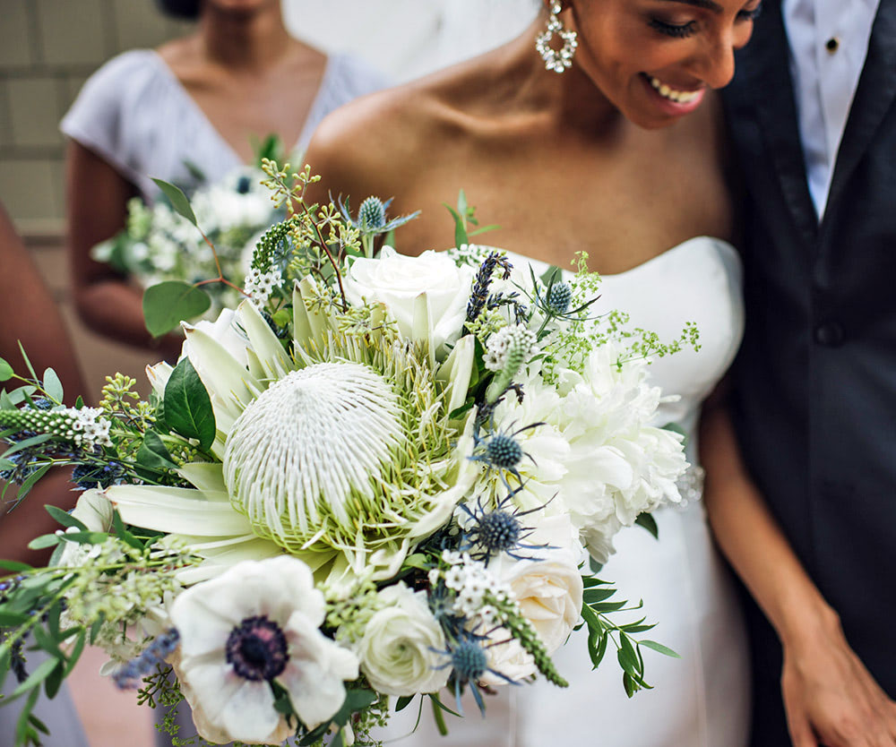 A freshly-wed bride and groom, smiling, depart the chapel